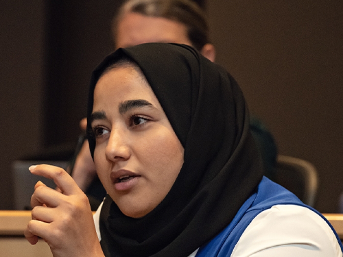 A woman with a headscarf asks a question at the MBoCA symposium