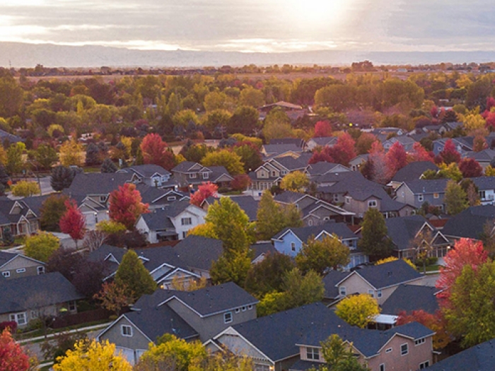 Aerial shot of a suburban neighborhood with the sun in the background