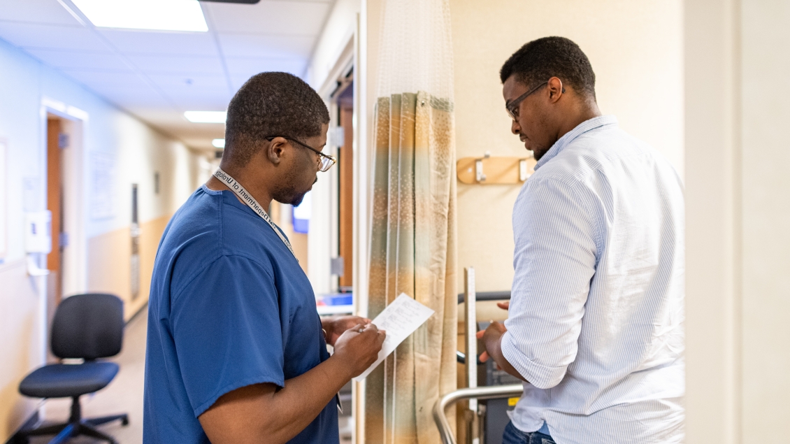Physician assistant and patient in a hallway
