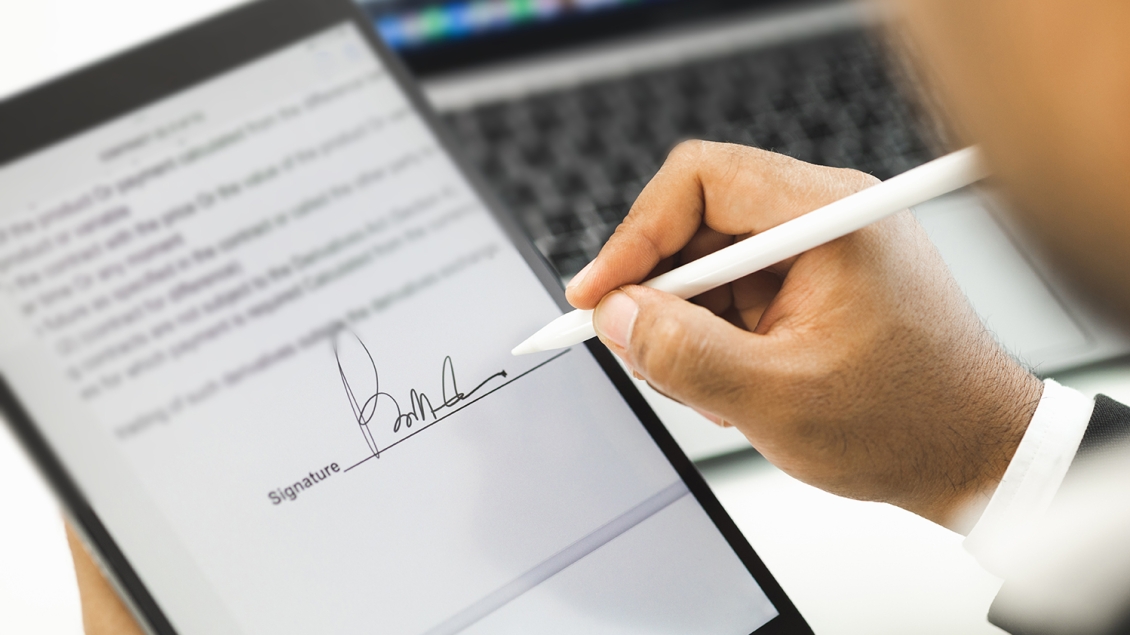 close-up of man signing electronic document