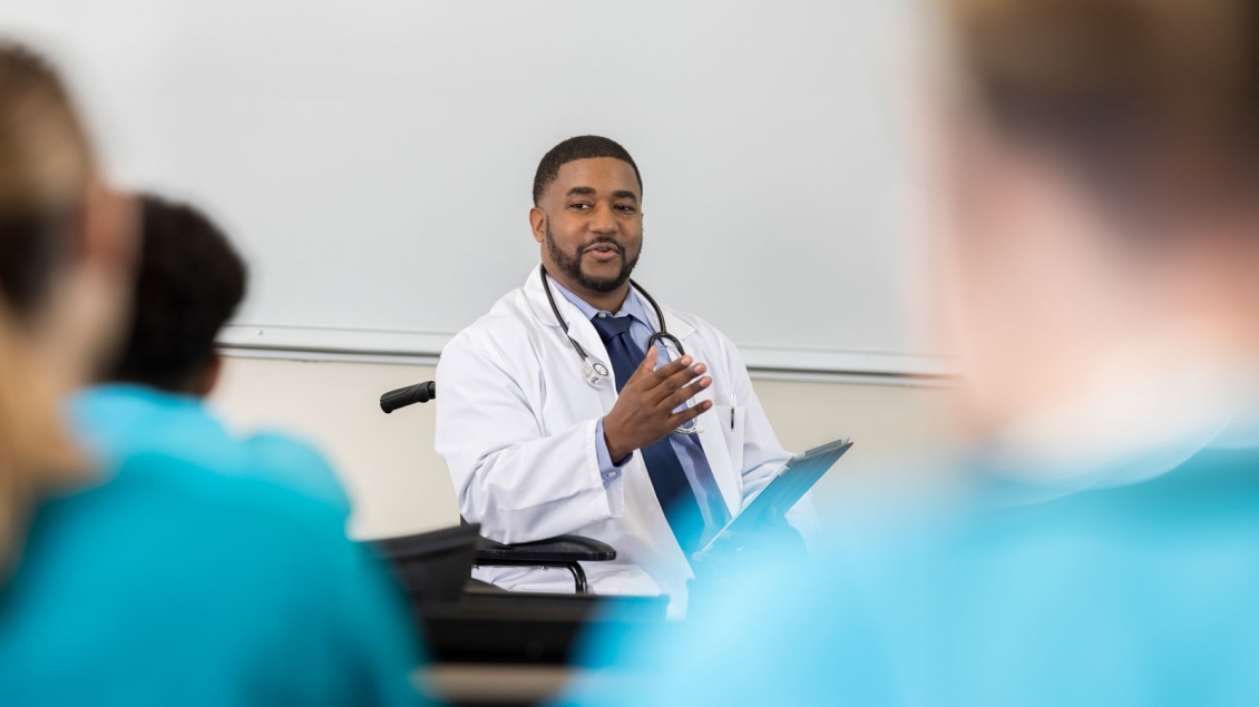 Medical Professor in wheelchair addresses class