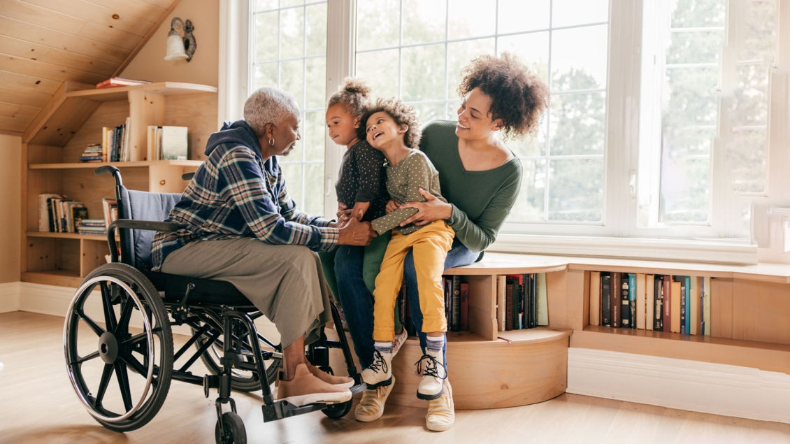 Grandmother in wheelchair with daughter & her two young daughters at the library