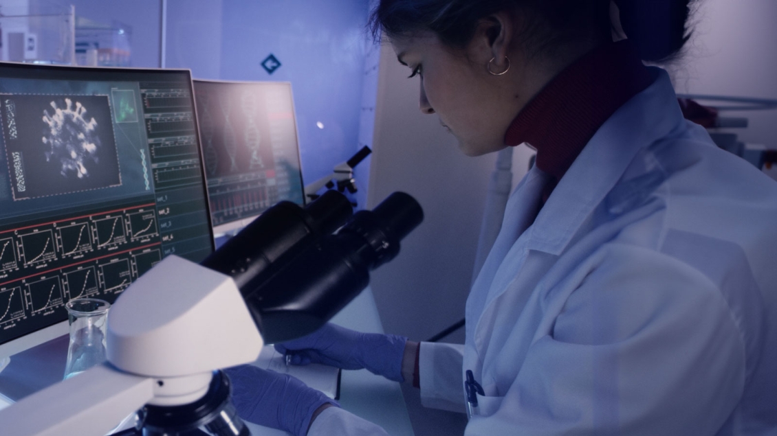 Female Scientist with screens displaying view under microscope