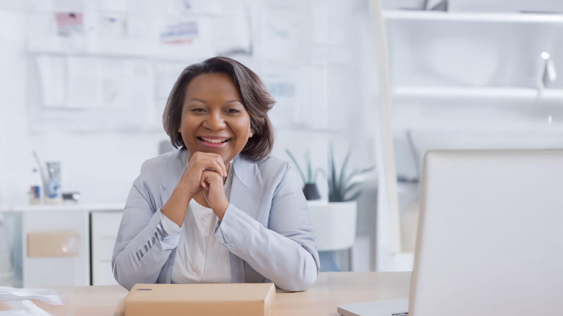 Woman smiling at table with laptop