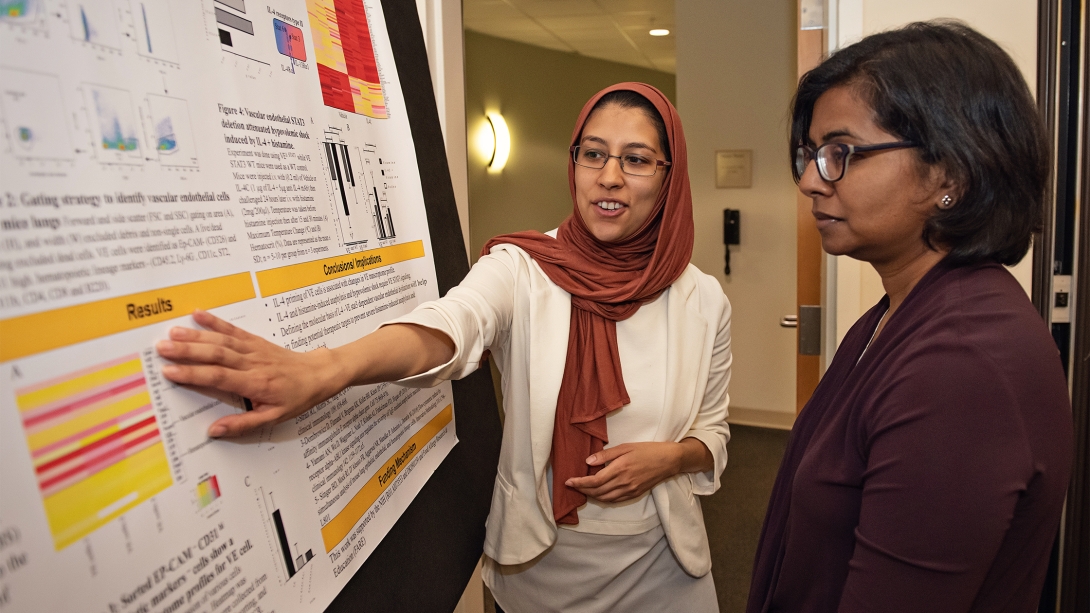 Women pointing and looking at the information board.