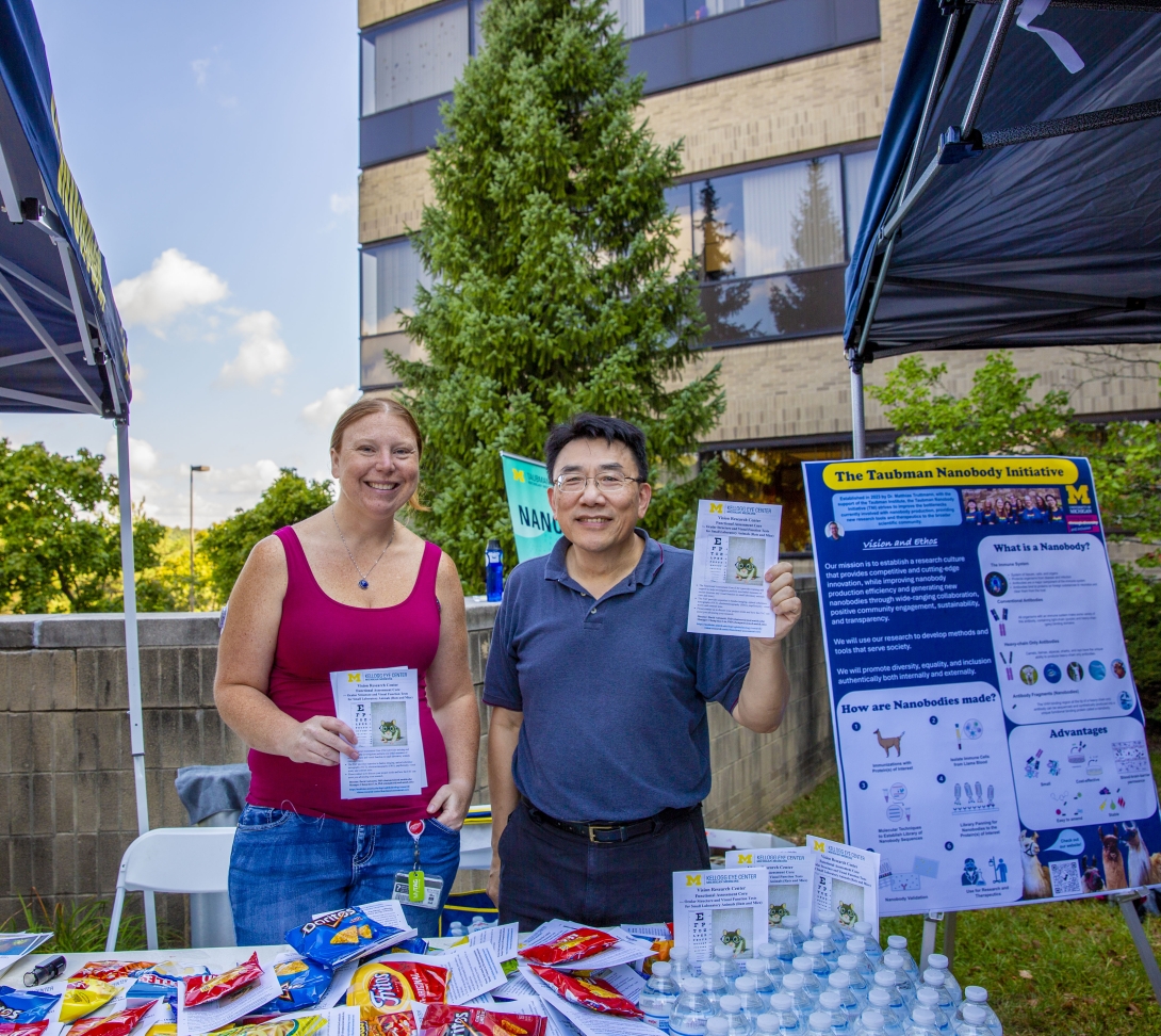 people posing at table at outdoor event