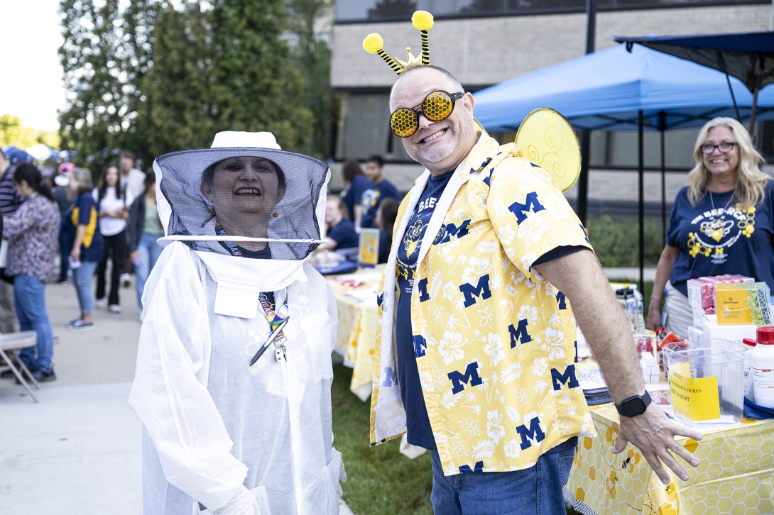 two people posing in costumes at outdoor event