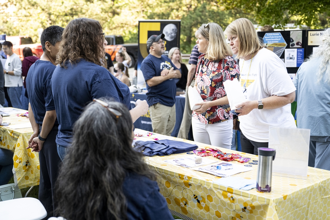 people talking at table at outdoor event