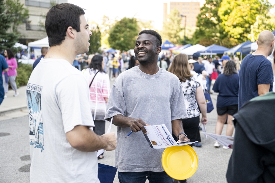 two people talking and smiling at outdoor event