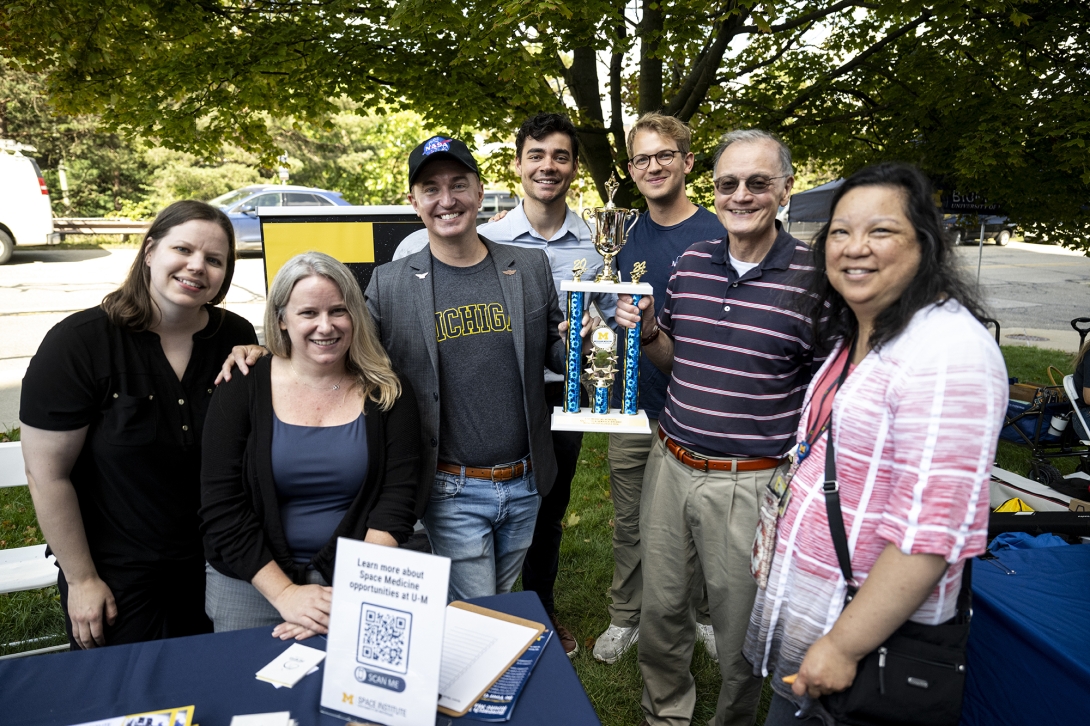 people posing at table at outdoor event