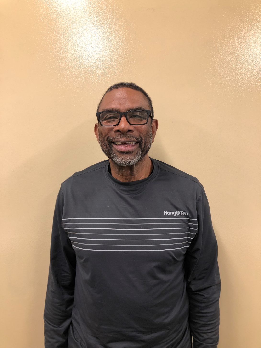 a man with glasses and a grey striped shirt