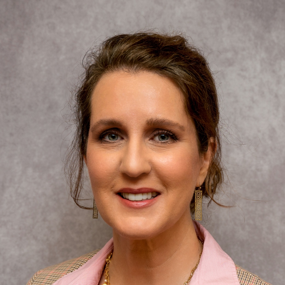 a woman with a pink shirt and updo 